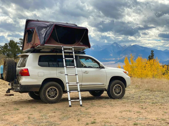 Looking for an RV rental? This overlanding SUV with a deployed rooftop tent and ladder offers unique mountain adventures in fall.. Toyota Land Cruiser 2016