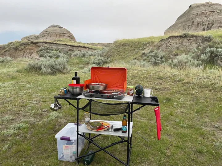 RV rental adventure: a portable camping kitchen set up for outdoor cooking amidst scenic badlands hills.. Coachmen Catalina SBX 221TBS 2019