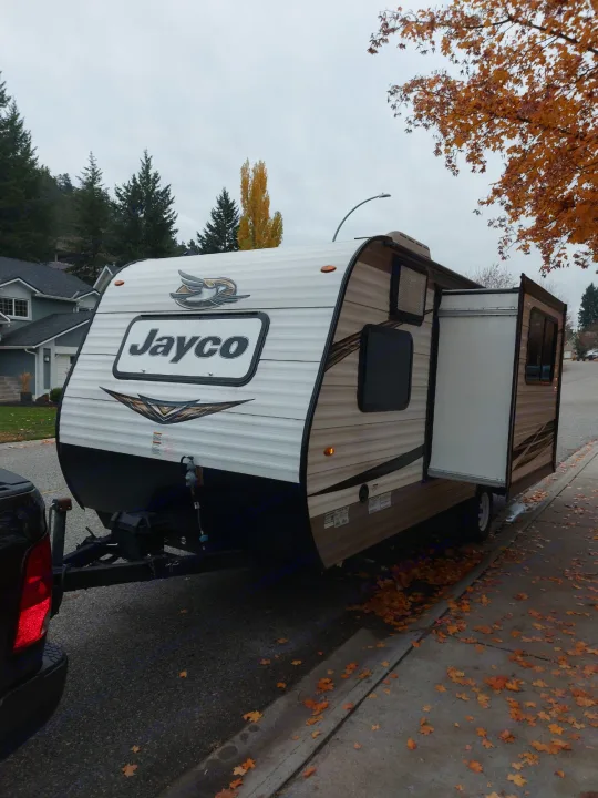 Jayco travel trailer (RV rental) parked on an autumn street with slide-out extended, ready for your next road trip.. Jayco Jay Flight SLX 2019