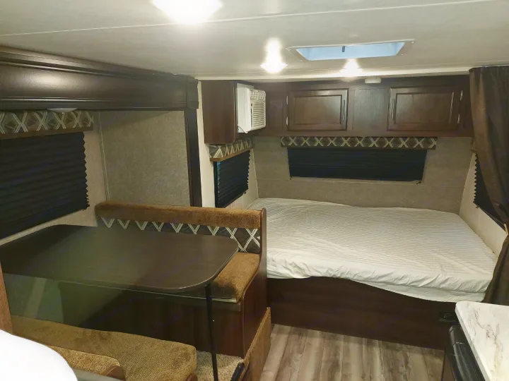 RV rental interior: A cozy bed, convertible dinette, AC unit, and overhead storage provide comfort for your adventures.. Jayco Jay Flight SLX 2019
