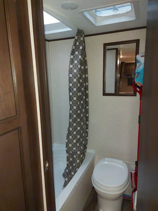 Inside an RV rental, this practical bathroom has a shower-tub combo, toilet, and ceiling vents, great for camping.. Jayco Jay Flight SLX 2019