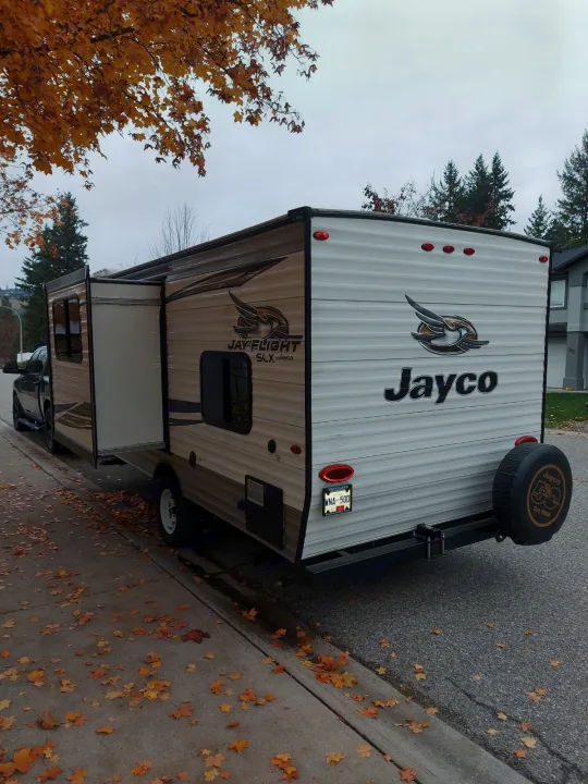A Jayco Jay Flight travel trailer in autumn, surrounded by fall leaves. An ideal RV rental for cozy adventures.. Jayco Jay Flight SLX 2019