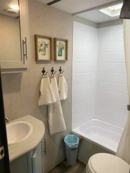 Explore this compact RV rental bathroom, featuring a shower/tub, vanity sink, and essential amenities for travel.. Keystone Bullet 2020