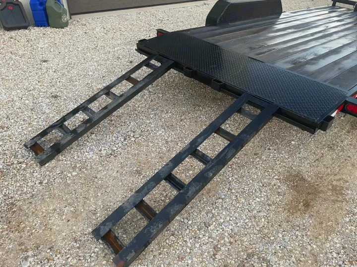 Utility trailer with sturdy pull-out ramps on gravel, perfect for hauling gear with your RV rental.. Other Other 2020