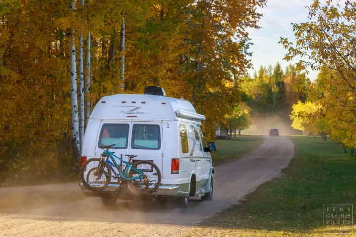 RV rental with bikes on a dusty autumn road, surrounded by vibrant fall foliage.. Ford FordE350 2006