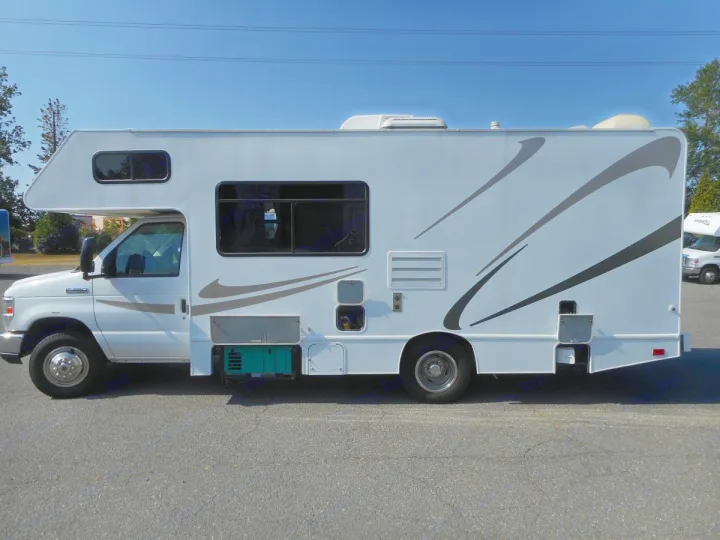 White Class C RV rental with graphics, a motorhome featuring a generator, parked on asphalt. Ideal camper for adventures!. Thor Majestic 2017