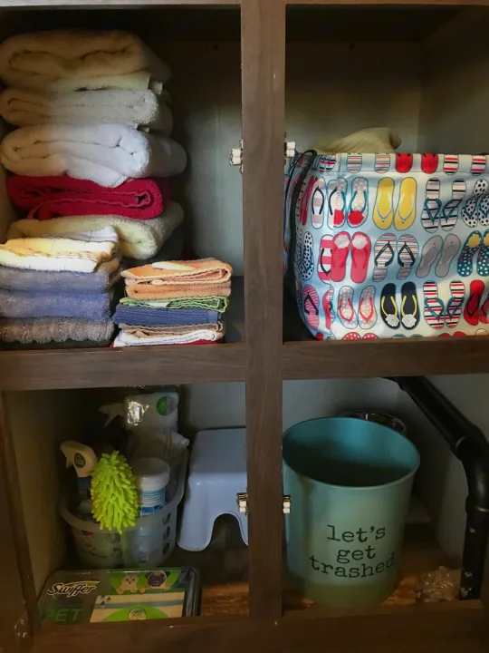 RV rental storage solutions: Neatly organized cleaning towels, pet-specific Swiffer, and a quirky trash bin in a compact RV.. Palomino Puma 2016