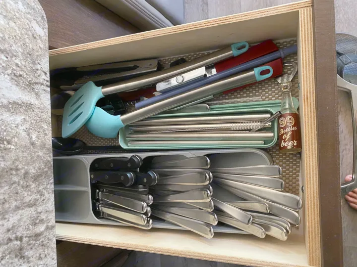 Organized kitchen drawer in an RV rental, featuring various utensils, spatulas, and a bottle opener.. Jayco Greyhawk 2019