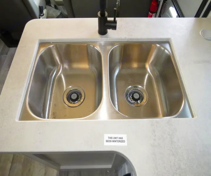 RV rental: Detailed view of a clean, double stainless steel kitchen sink and faucet, marked winterized.. Entegra Coach Odyssey 30Z 2022