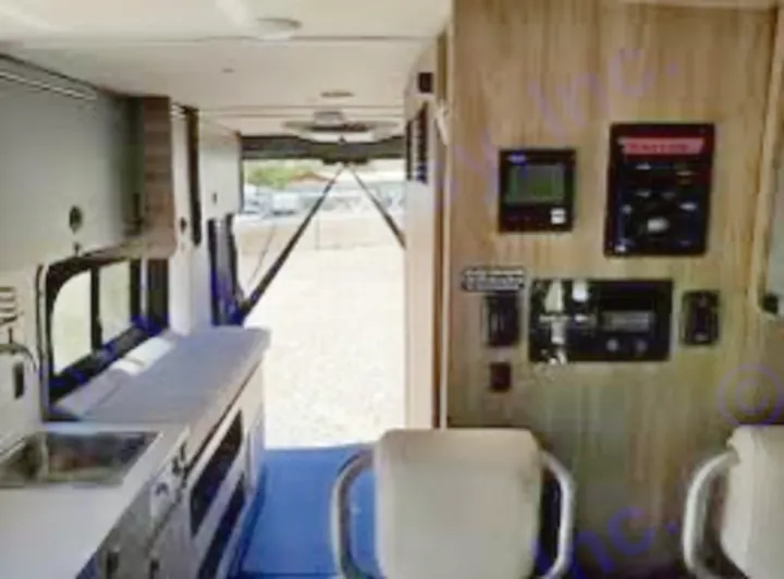 Inside this RV rental: a compact kitchen on the left, control panels on the right, and an open back door. Ready for travel!. Winnebago Solis 59PX 2022