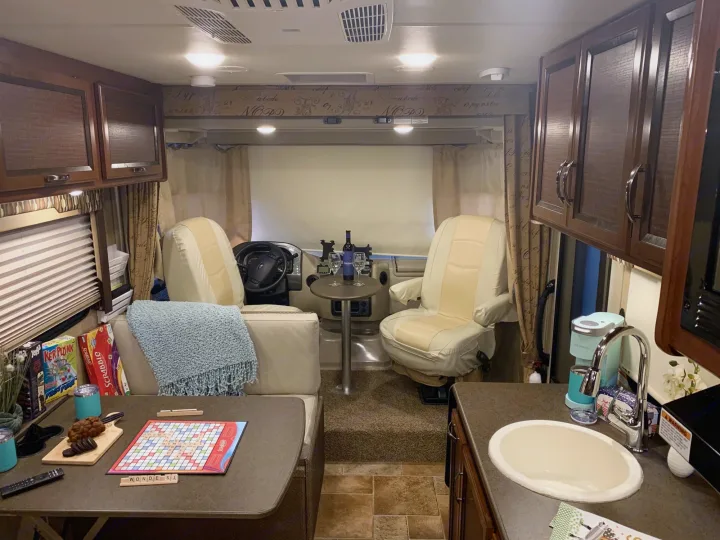 Cozy RV rental interior featuring a living area, games, kitchen, and cockpit. Perfect for travel adventures.. Thor Vegas 2016