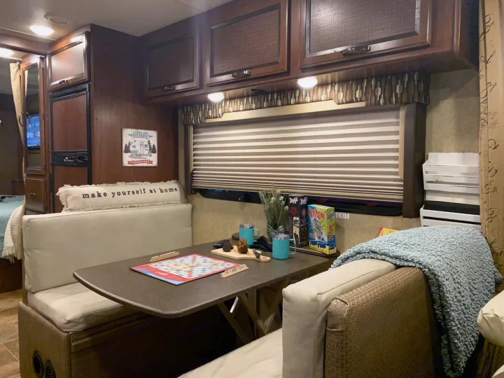 Cozy RV rental interior with a comfortable dining booth, featuring Scrabble, snacks, mugs, and games.. Thor Vegas 2016