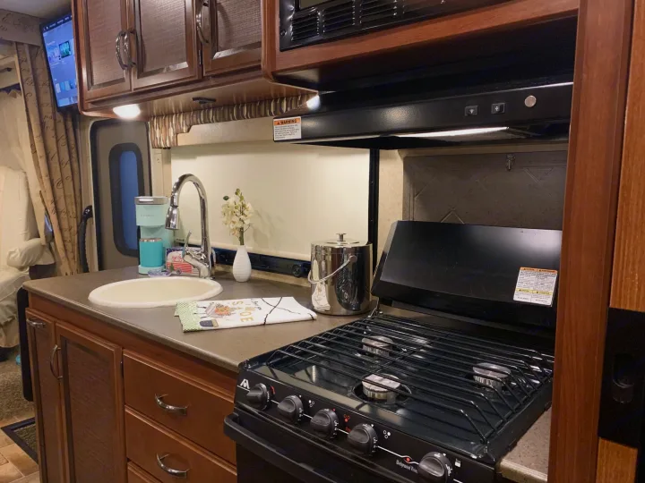 RV rental kitchen: sink, Keurig, Wedgewood stove, overhead microwave. Compact interior provides essentials.. Thor Vegas 2016