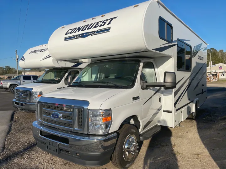 Two white Conquest Gulf Stream motorhomes, likely for rv rental, parked on gravel under a clear sky.. Gulf Stream Conquest 2021