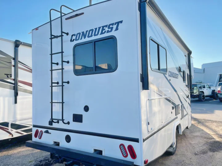 This RV rental photo shows the rear of a white Conquest motorhome with a ladder, windows, and taillights, ready for adventure.. Gulf Stream Conquest 2021