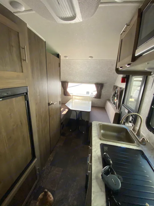 Cozy RV rental interior: kitchen with sink & stovetop, fridge, and dinette seating area.. ROULOTTE PROLITE ROULOTTE PROLITE 2020