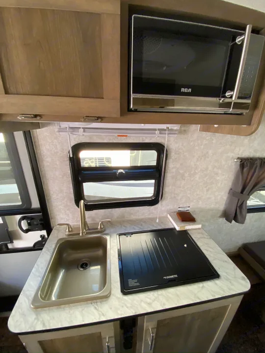 RV rental kitchen features a stainless sink, Dometic cooktop, and RCA microwave for convenient travel.. ROULOTTE PROLITE ROULOTTE PROLITE 2020