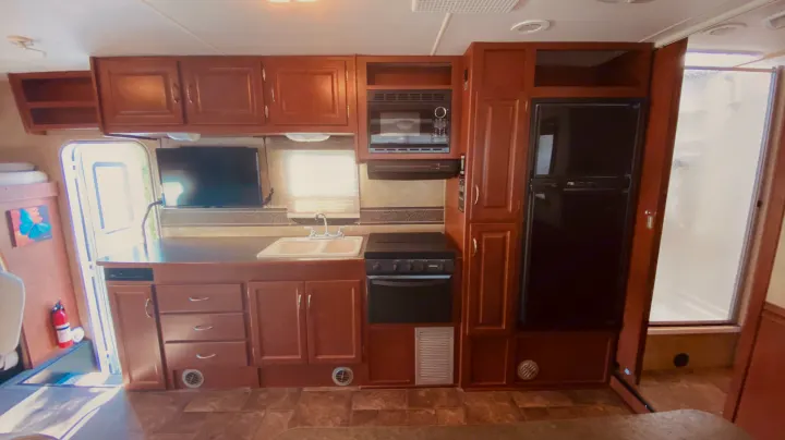 This RV rental features a full kitchen with a fridge, stove, and microwave, plus a TV and shower. Perfect for travel!. Winnebago 31k 2015
