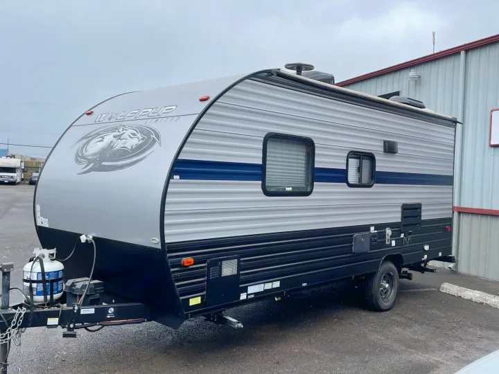 Explore with this Wolf Pup travel trailer, an ideal rv rental. Grey and black RV with a blue stripe, ready for adventure.. Forest River Cherokee Wolf Pup 2019