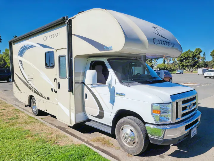 A modern white and tan Thor Chateau RV, available for rv rental, parked outdoors on a sunny day.. Thor Chateau 2018