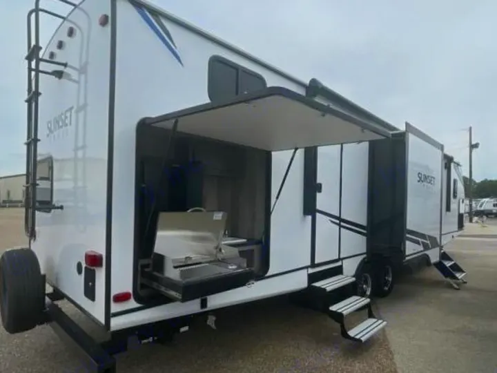 White Sunset RV rental featuring an open outdoor kitchen with grill, rear ladder, and deployed side steps. Your adventure awaits!. Crossroads Sunset Trail Super Lite 2022