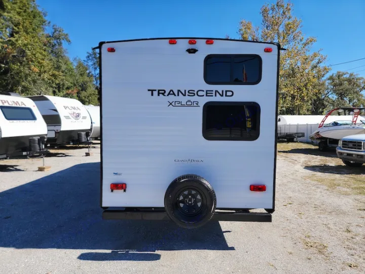Rear view of a white Grand Design Transcend Xplor travel trailer for rv rental. Other campers are parked nearby.. Other Other 2021