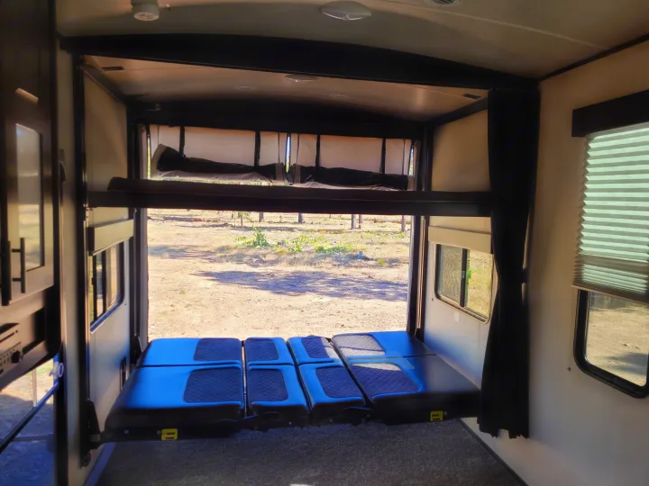 RV rental: Inside a toy hauler with elevated bunk beds & convertible lower seating, offering great views for camping trips.. Heartland Fuel 305 2018