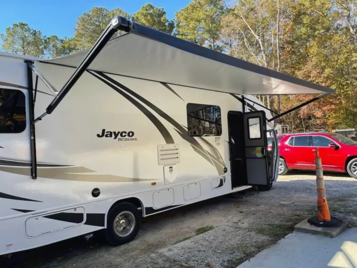 White Jayco Redhawk RV rental with its awning extended, parked outdoors.. Ford Ford 2022