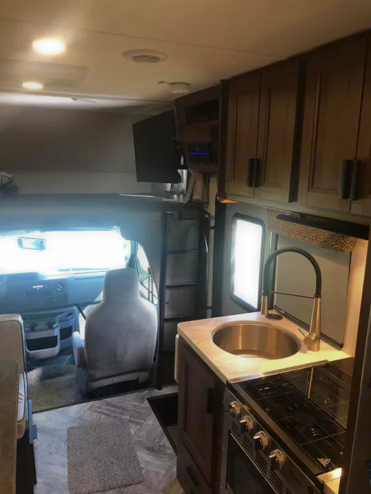 Explore this well-equipped RV rental's interior, featuring a kitchen, overhead bunk, and cockpit for your next adventure.. Forest River Other 2021