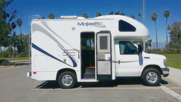 White Majestic Class C RV rental parked, door open. Ready for travel adventures under blue skies & palm trees.. Thor 2012 Thor 19G 2012