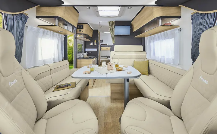 This bright, modern RV rental interior features cream dining and living areas with a table, ample storage, and windows.. ITINEO CS660 2022