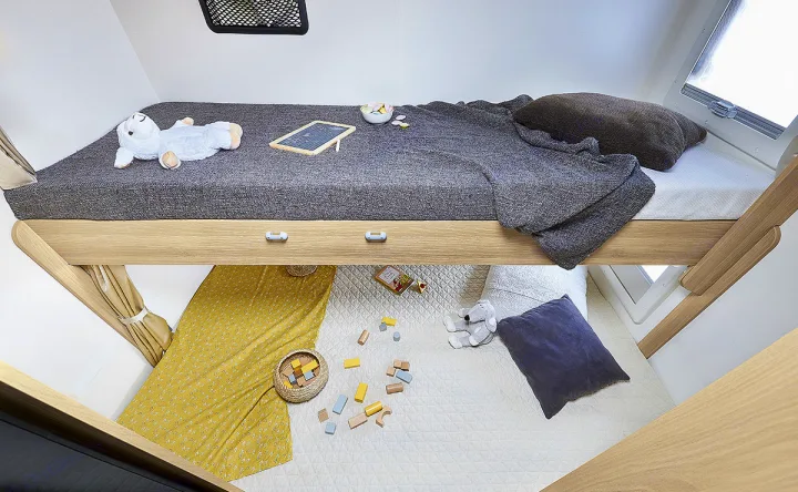 Inside an RV rental: a bright bunk bed setup with a cozy top bunk for sleeping and a lower padded area for kids' playtime.. ITINEO CS660 2022