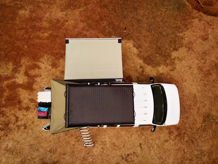 Overhead view of an overlanding vehicle with rooftop tent & awnings, fully set up for adventure. Explore rv rental options!. Ford Econoline 2009
