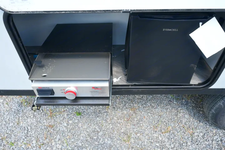 This RV rental's outdoor kitchen includes a pull-out Suburban griddle and Everchill fridge for convenient camping.. Forest River Wildwood FSX 2022