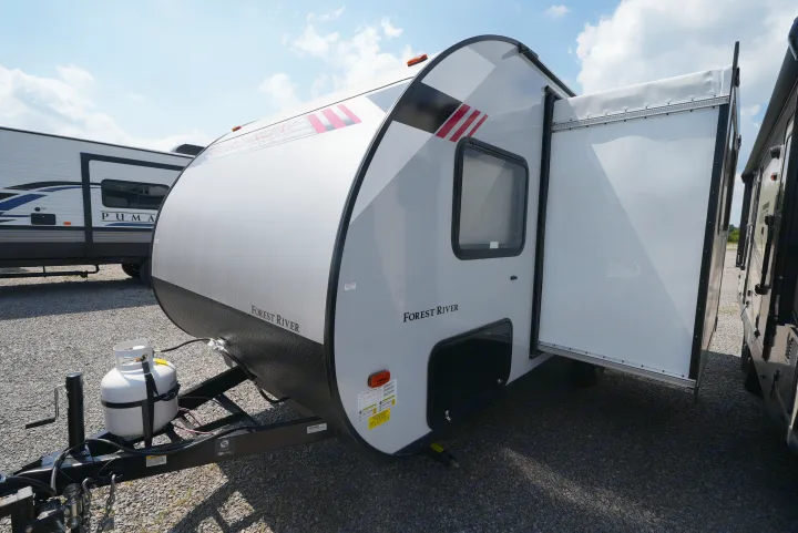 A modern Forest River travel trailer with its side expanded, perfect for an RV rental. Propane tank at front.. Forest River Wildwood FSX 2022