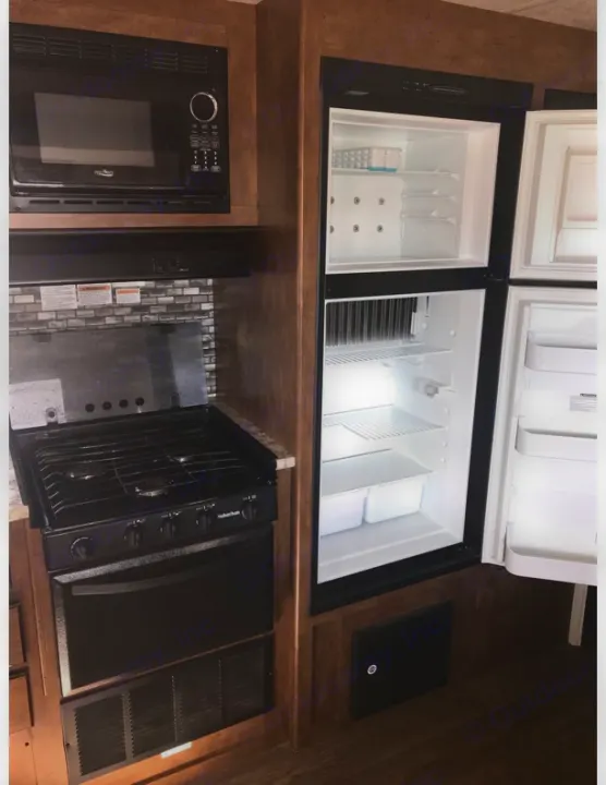 RV rental kitchen featuring a compact microwave, gas stove & oven, plus a two-door refrigerator. All essentials for travel.. Forest River Salem Cruise Lite 2018
