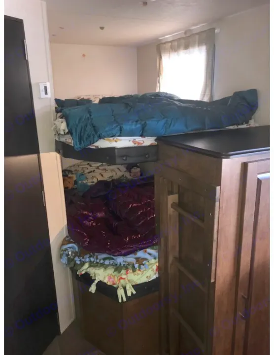 RV rental bunk room: stacked beds (teal & purple comforters), wood cabinetry, and a thermostat. Cozy, compact space.. Forest River Salem Cruise Lite 2018