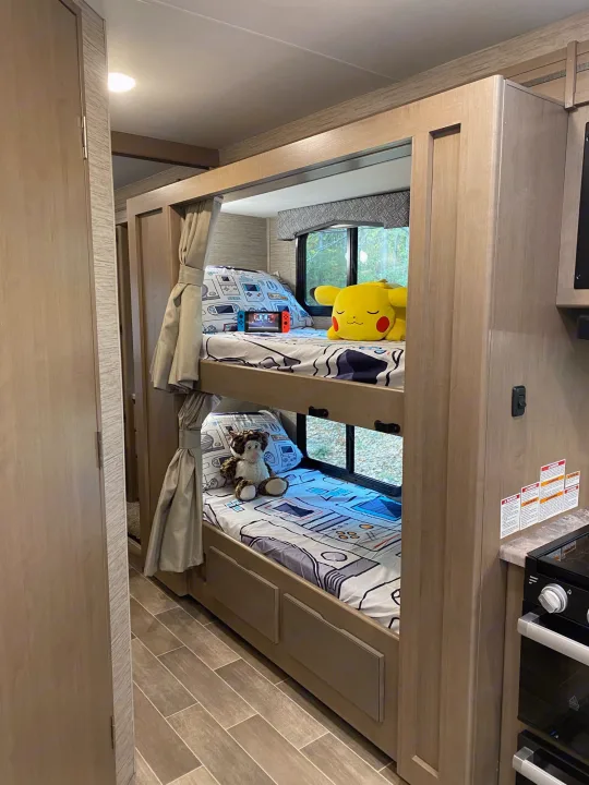 Cozy RV rental bunks, perfect for family adventures, featuring game-themed bedding, a Switch, and plush toys.. Thor Magnitude GA 2022