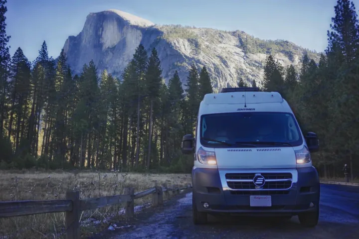 White rv rental van at Yosemite, with iconic Half Dome and towering pine forests in the background. Great for scenic travel.. Hymer Hymer Class B 2019