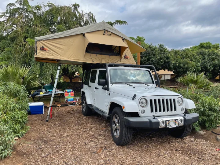 White Jeep Wrangler with a TEPUI rooftop tent deployed for camping. An excellent rv rental alternative for Maui overland adventures.. Jeep Wrangler 2017