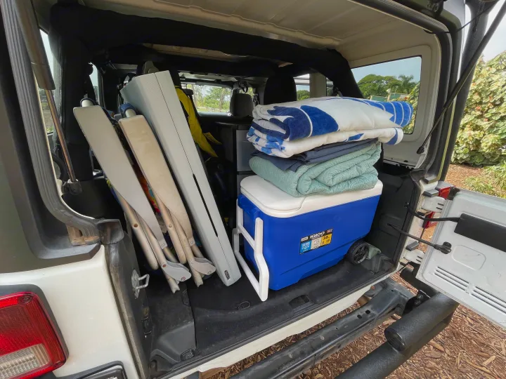 Cooler, blankets, chairs: RV rental trunk packed for an outdoor trip.. Jeep Wrangler 2017
