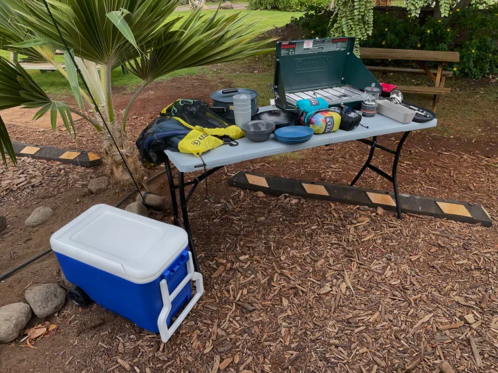 RV rental trip essentials: Coleman stove, cooking gear, cooler on a table, ready for campsite dining.. Jeep Wrangler 2017