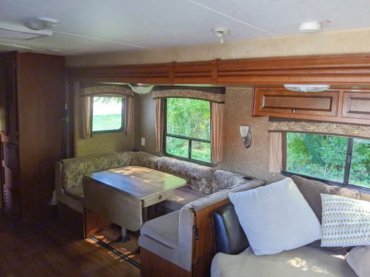Explore this comfy RV rental interior: a bright dinette and cozy living space amidst nature views.. Jayco Jay Flight 2012