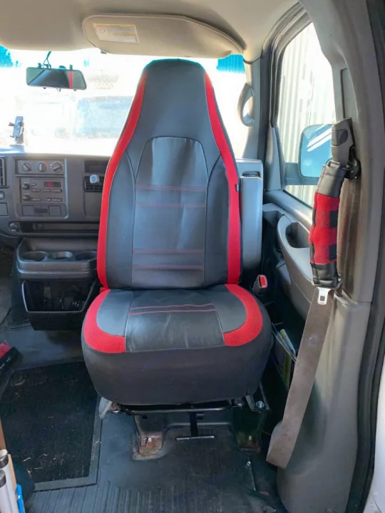Inside an RV rental van: passenger seat with black & red cover, dashboard, phone mount, and seatbelt.. Chevrolet Express Extended 2007