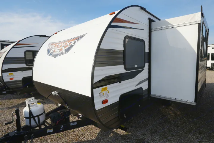 White Forest River Wildwood FSX travel trailer with an extended slide-out, ready for RV rental.. Wildwood FSX 178BHsk 2022