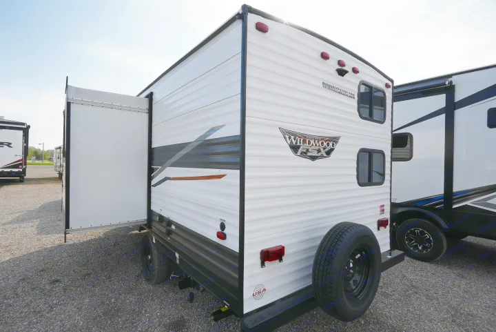 A white Forest River Wildwood FSX travel trailer with its rear ramp door open, ideal for RV rental.. Wildwood FSX 178BHSK 2022