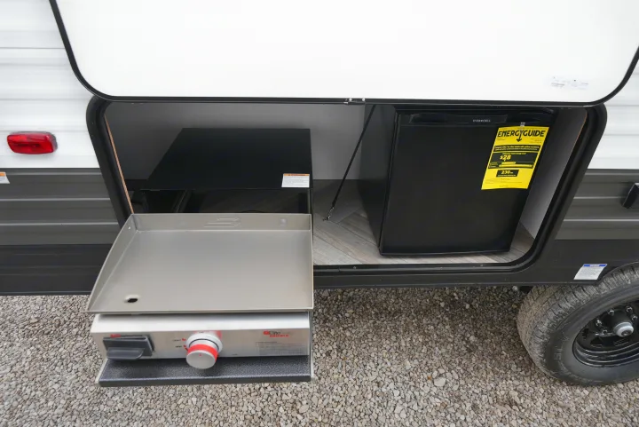 This RV rental features an outdoor kitchen with a pull-out griddle and a built-in mini-fridge for convenience.. Wildwood FSX 178BHSK 2022