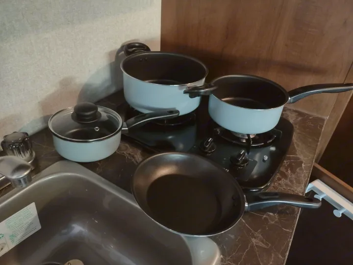 Compact kitchen in an RV rental, featuring pots, pans, a stove, and a sink, ready for cooking on the go.. Jayco Jay Flight 2017