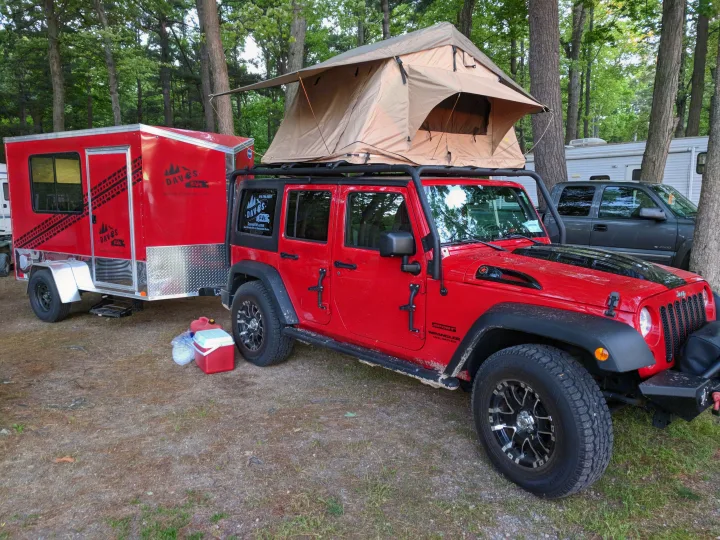 Red Jeep Wrangler with roof-top tent & matching trailer, perfect for an rv rental adventure in a wooded campsite.. United XLMTV-610 2018