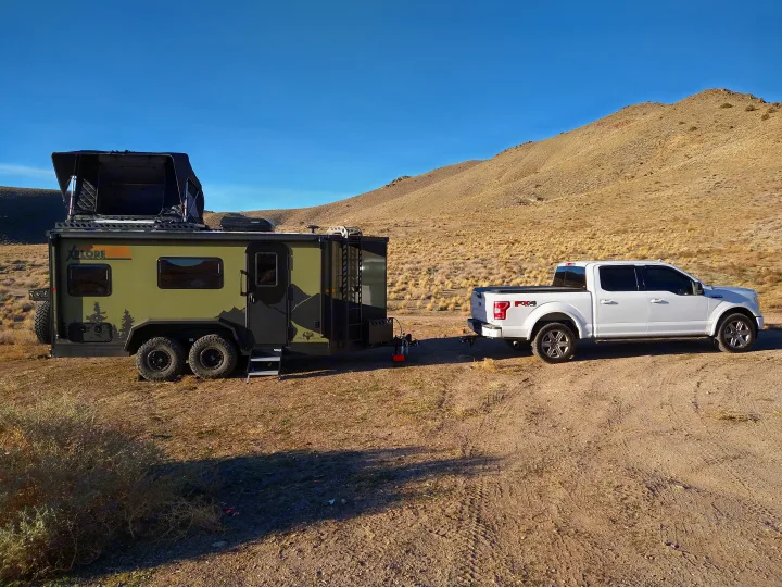 White F-150 tows a rugged XPLORE off-road trailer. Your ultimate rv rental for desert adventures!. Xplorer X22 2022